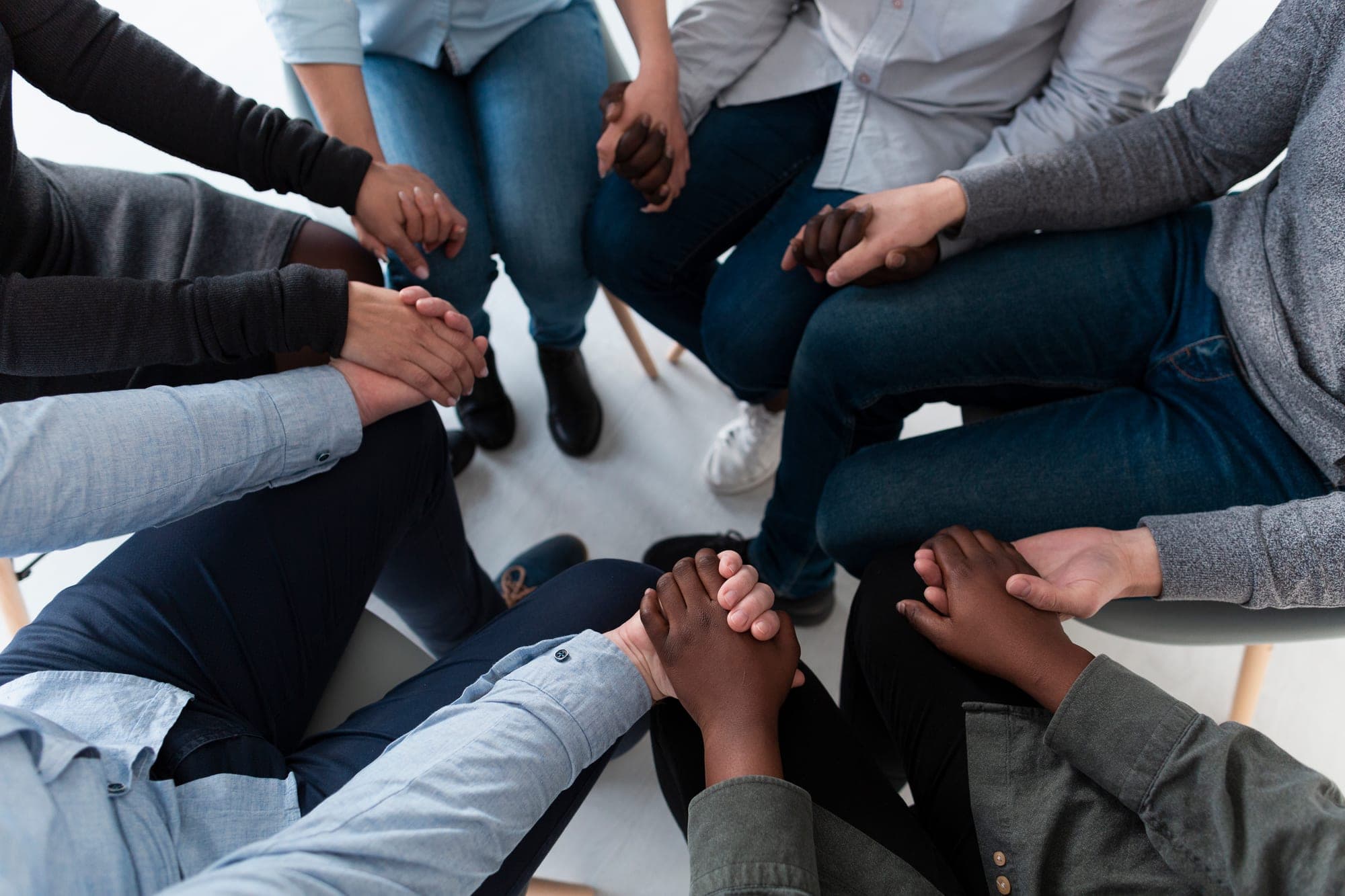 A circle of people holding hands during a retreat